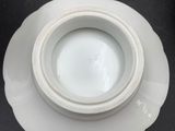 a white plate with a bowl on it on a black table