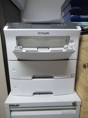 trois imprimantes blanches empilées les unes sur les autres dans une pièce
