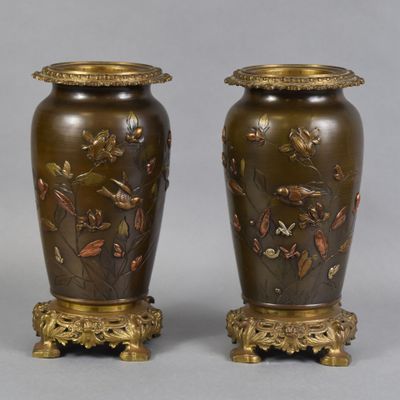 pair of bronze vases with birds and flowers on them