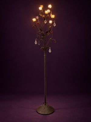 un grand sapin en métal surmonté de cinq lumières, sur fond violet