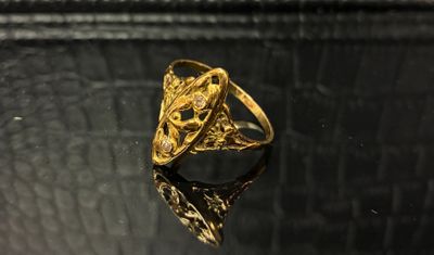 gros plan d'une bague en or posée sur une surface noire