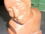 une sculpture en argile représentant la tête d'un homme, posée sur une table
