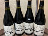 three bottles of wine are lined up on a wooden tray