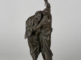 a bronze statue of a man and woman holding an umbrella