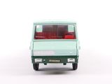 a green toy van with red seats on a white surface