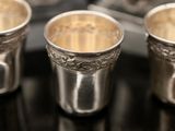 three silver cups sitting on top of a black table next to each other