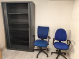two blue office chairs sitting next to each other in a room