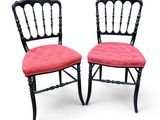 une paire de chaises noires avec des coussins rembourrés roses