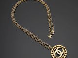 un collier en or avec un pendentif circulaire et une chaîne