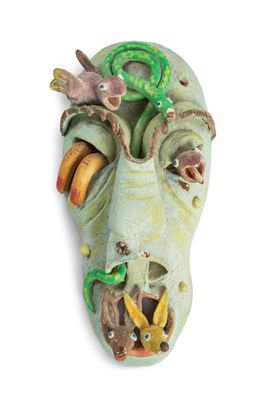 un masque vert sur lequel est représenté un oiseau