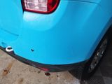 a small blue car parked on the side of the street