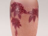a pink vase with purple flowers on it on a white background
