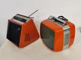 two orange televisions sitting on a table next to each other