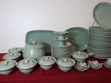many plates and bowls on a table with a red table cloth