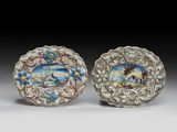 deux petites assiettes ornées de scènes peintes, posées sur une table