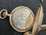 a silver pocket watch with a chain attached to it
