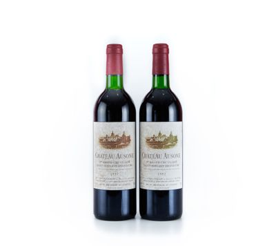 deux bouteilles de vin rouge posées l'une à côté de l'autre sur une surface blanche
