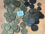 un tas de pièces de monnaie posées sur une table, avec une étiquette bleue