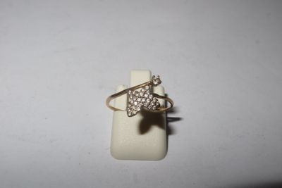un gros plan d'une bague sertie de diamants posée sur une surface blanche
