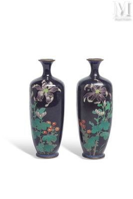 pair of black vases with floral designs on them against a white background
