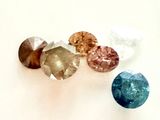 trois pierres de couleurs différentes sont disposées sur une surface blanche