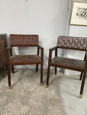 pair of mid - century style chairs with woven seats in a living room