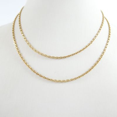 un gros plan d'un collier à chaîne en or porté par un mannequin