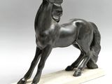 a bronze statue of a horse on a marble base