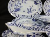 four pieces of blue and white china on a black background