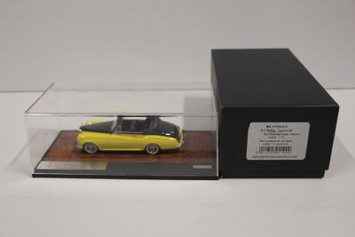 la voiture jaune se trouve dans une boîte transparente posée sur une surface blanche