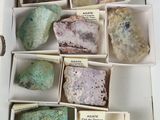plusieurs pierres de différentes couleurs dans une boîte blanche, accompagnées d'étiquettes