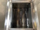 a stainless steel fryer with a basket inside of it