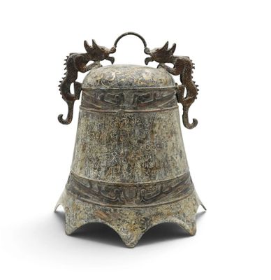 une clochette en métal ornée d'hippocampes sur un fond blanc
