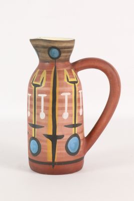 un petit vase avec un motif sur une surface blanche