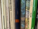 many books that are on a shelf next to a clock