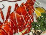 a plate with a lobster on it with a sign on it