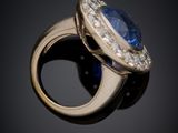 an oval blue sapphire and diamond ring on a black background