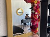 a mirror hanging on the wall with flowers on it
