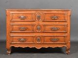 a wooden chest of drawers with ornate handles and drawers on each side
