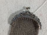 une pochette ancienne en cotte de mailles argentée, à laquelle est attachée une étiquette