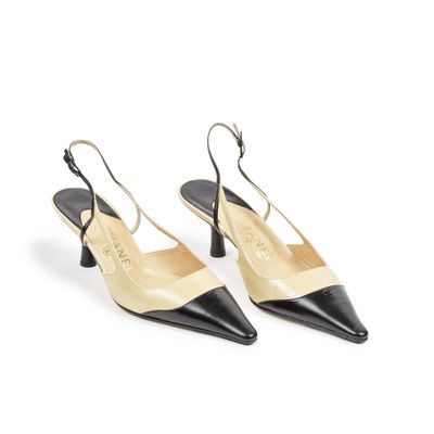 une paire de sandales en cuir noir et beige sur fond blanc