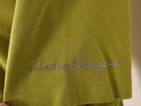the back of a woman ' s green shirt with the word alohe sequin written on it