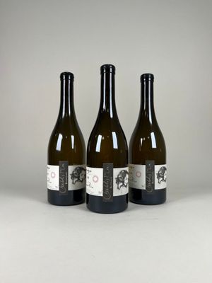 trois bouteilles de vin posées l'une à côté de l'autre sur une table