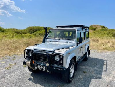 une photo d'un Land Rover blanc garé dans un champ