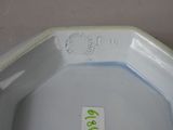 a close up view of a white bowl with a green label on it