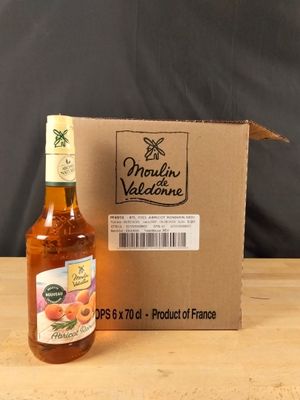 une bouteille de vin de pêche posée à côté d'un carton sur une table en bois