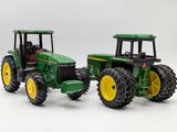 two toy tractors that are sitting next to each other