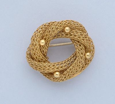 une image représentant une broche en or sur fond blanc