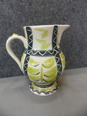 un vase vert et blanc posé sur une table