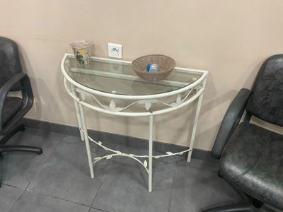 une table en verre sur laquelle se trouve un bol, à côté de deux chaises